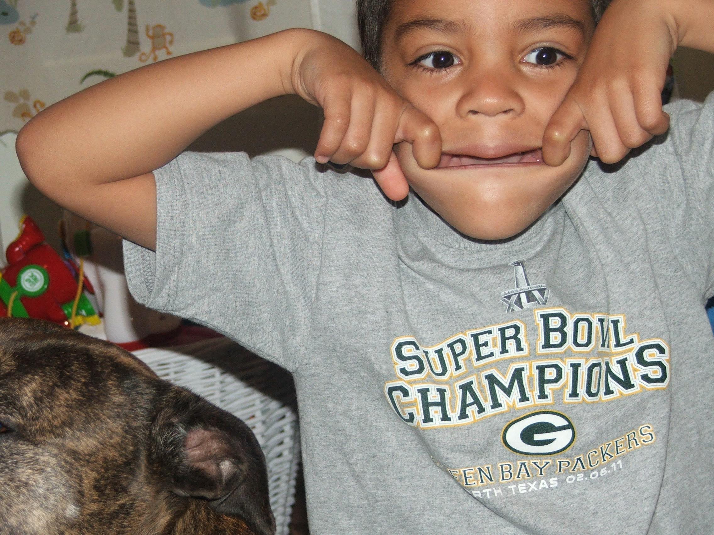 Me as a young lad being silly and sticking out my tongue. I am wearing a Green Bay Packers t-shirt.